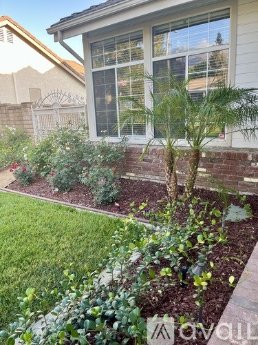 A house with a white fence and a garden in front.