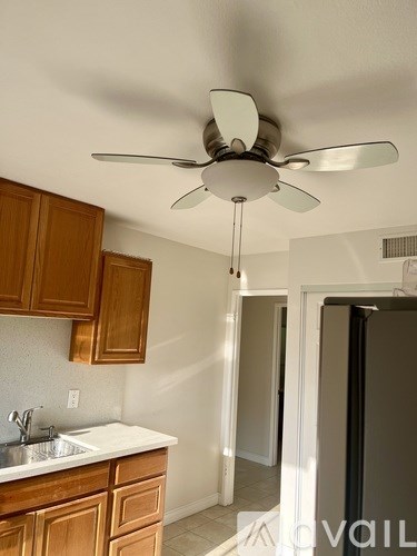 A kitchen with a fan hanging from the ceiling.