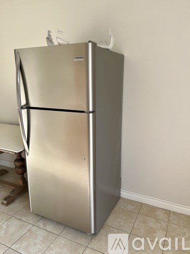 A stainless steel refrigerator with a water and ice dispenser on top.