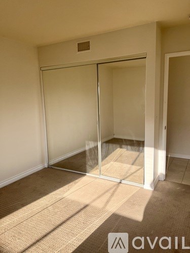 A room with a carpeted floor and a sliding glass door.