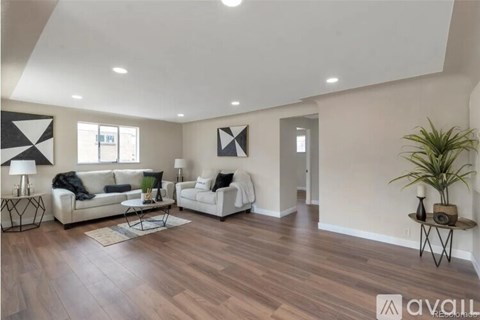 A living room with a white couch and a wooden floor.
