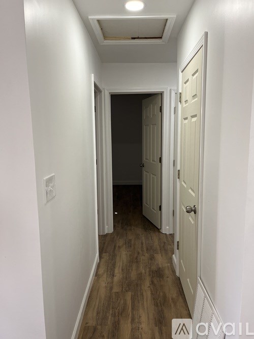 A hallway with a door on the right and a light on the ceiling.