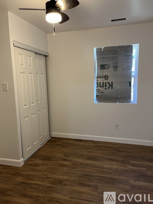 A room with a white door and a window covered with a poster.