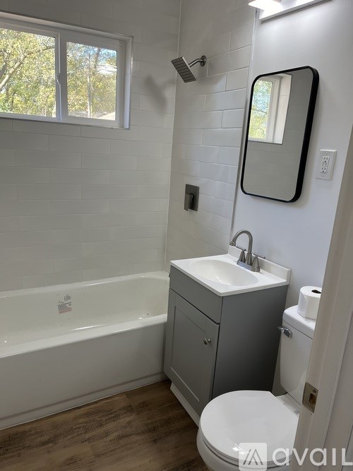 A bathroom with a white tub, sink, and toilet.