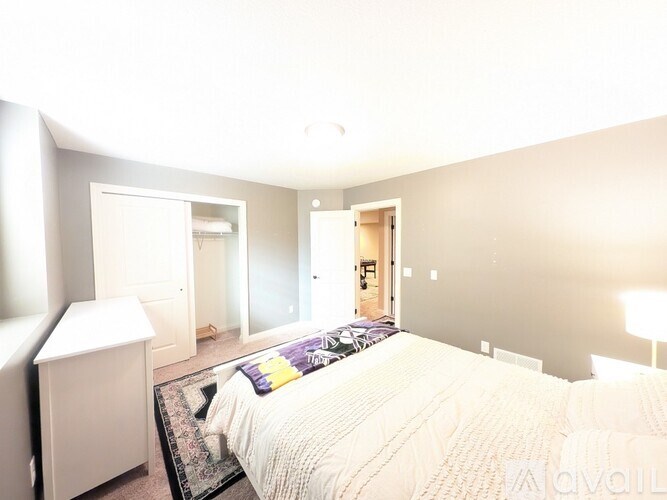 A bedroom with a bed, nightstand, and lamp.