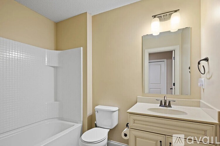 A bathroom with a toilet, sink, and bathtub.