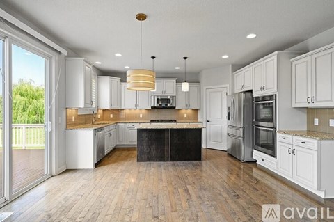 A modern kitchen with white cabinets and a center island.