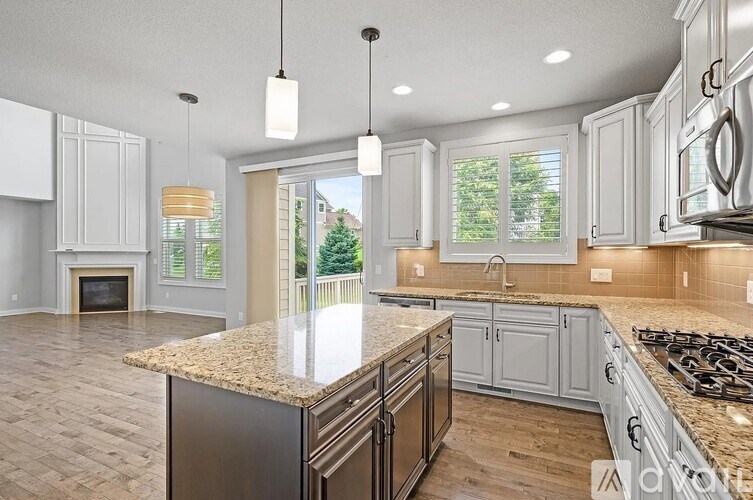 A kitchen with a granite countertop and stainless steel appliances.