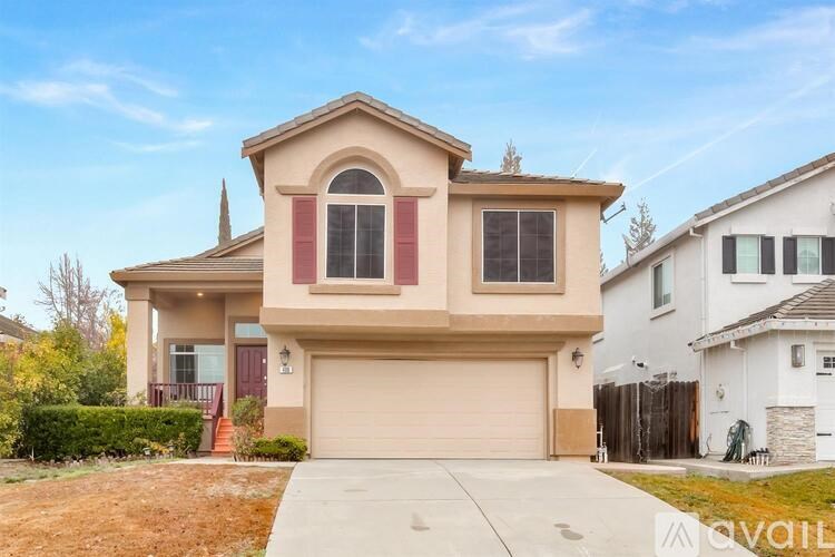 A two-story house with a garage is available for sale.