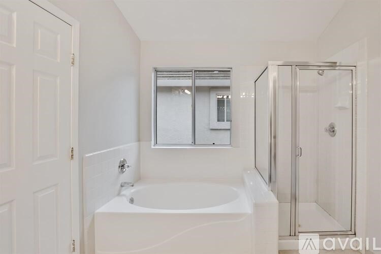 A white bathroom with a tub and a shower.