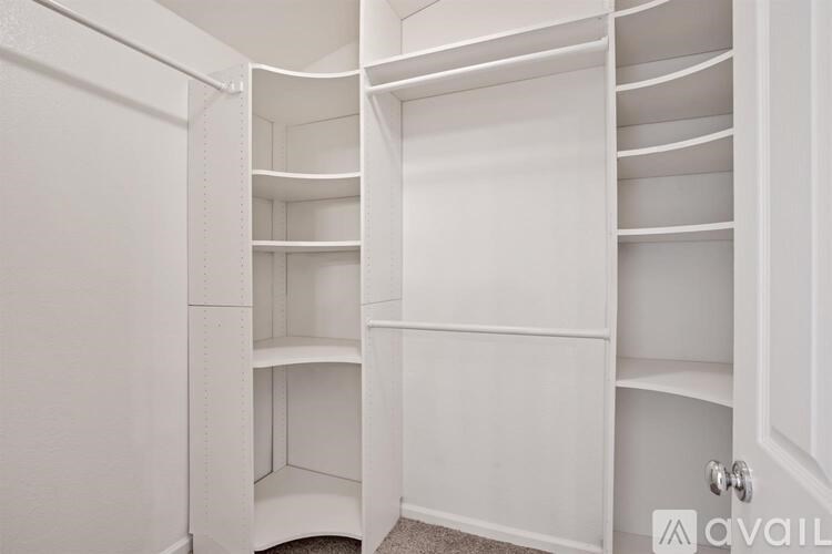 A white pantry with open doors and shelves.