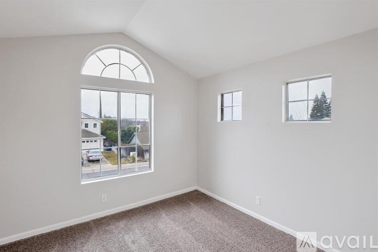 A room with a large arched window and two smaller windows.