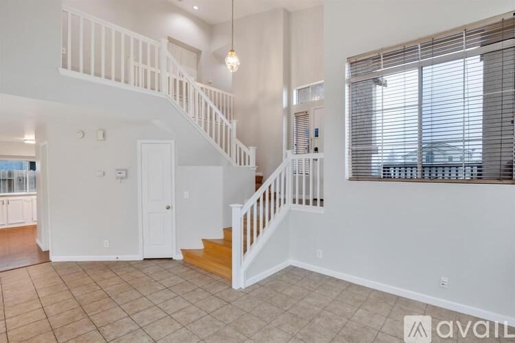 A spacious living room with a staircase leading to the upper floor.