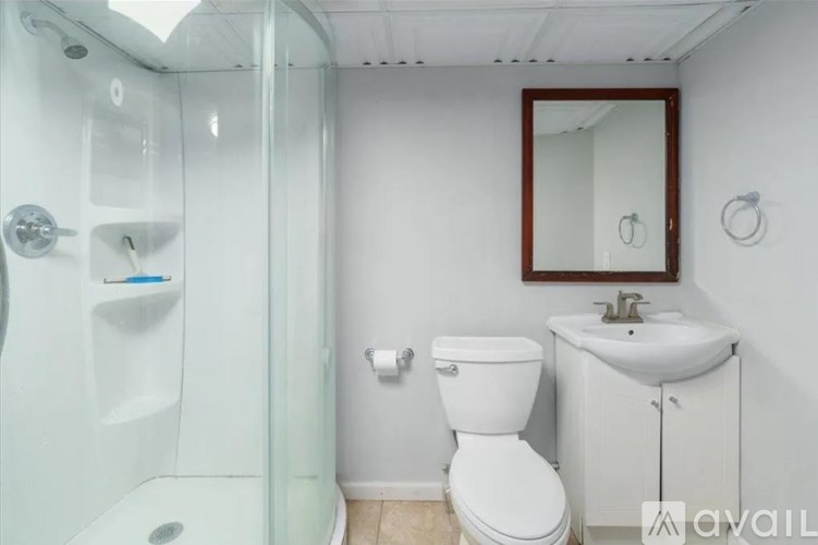 A bathroom with a toilet, sink, and shower.