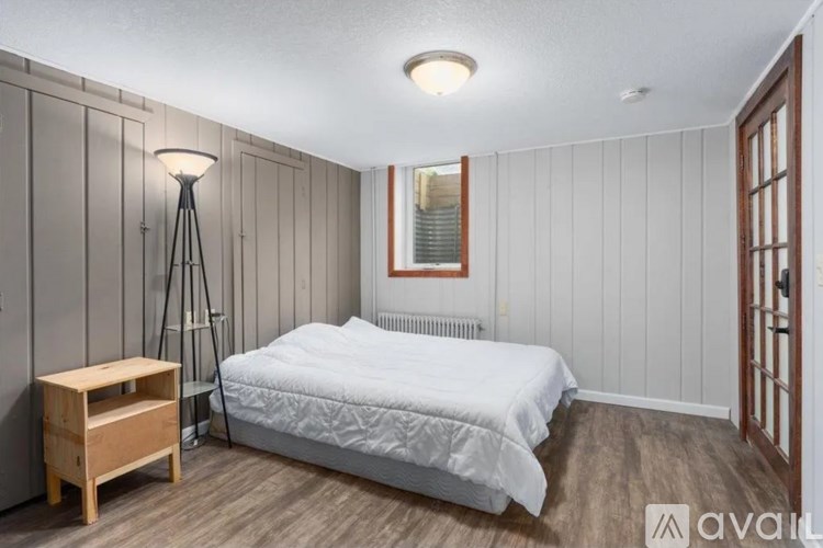 A bedroom with a bed, nightstand, and lamp.