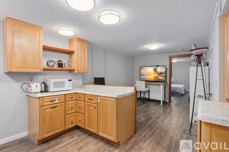 A kitchen with wooden cabinets and a white microwave.