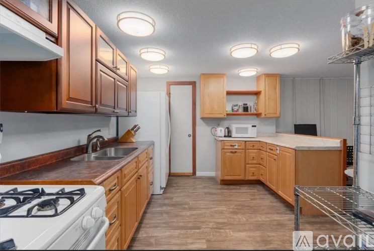 A kitchen with wooden cabinets and a white stove top oven.