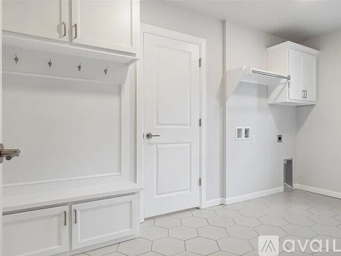 A white kitchen with a door and a cabinet.
