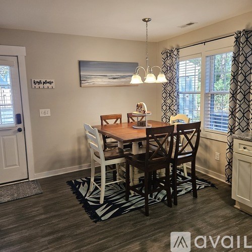 A dining room with a wooden table and chairs.