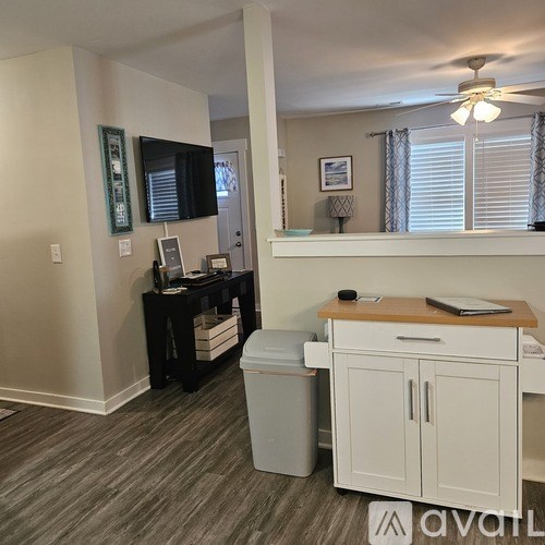 A room with a desk, a mirror, and a trash bin.