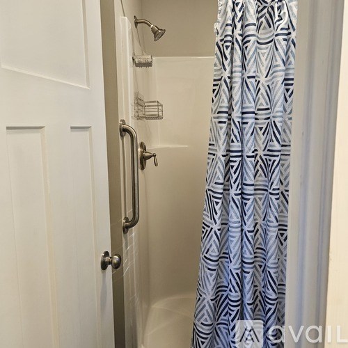 A shower with a blue and white patterned shower curtain.
