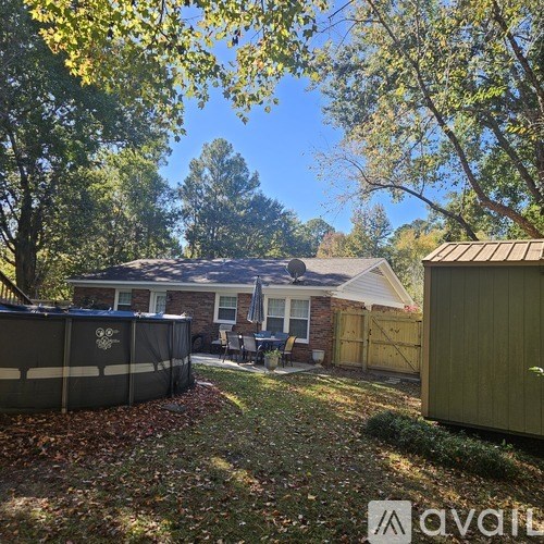 A backyard with a hot tub and a shed.