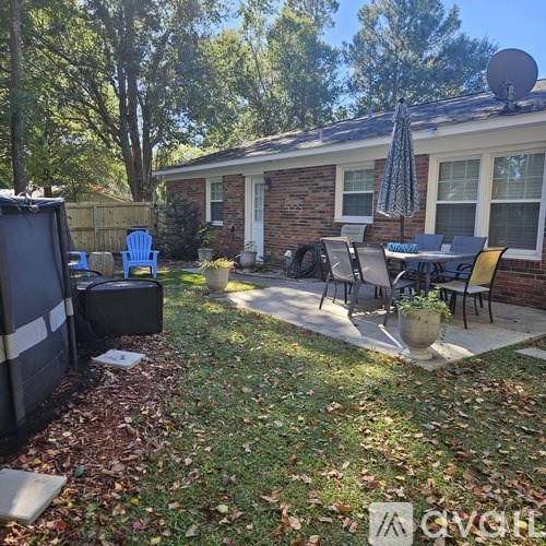 A backyard with a patio table and chairs.