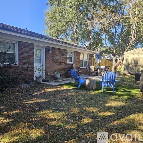 A backyard with a blue lawn chair and a small table.