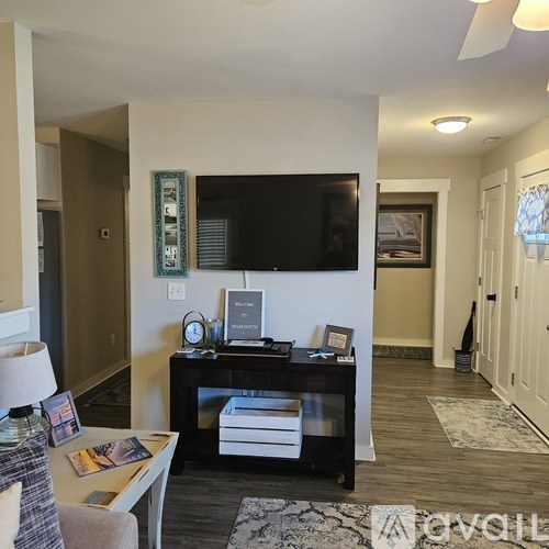 A living room with a flat screen TV mounted on the wall.