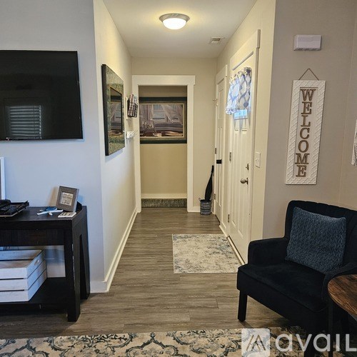 A hallway with a black couch and a welcome sign.