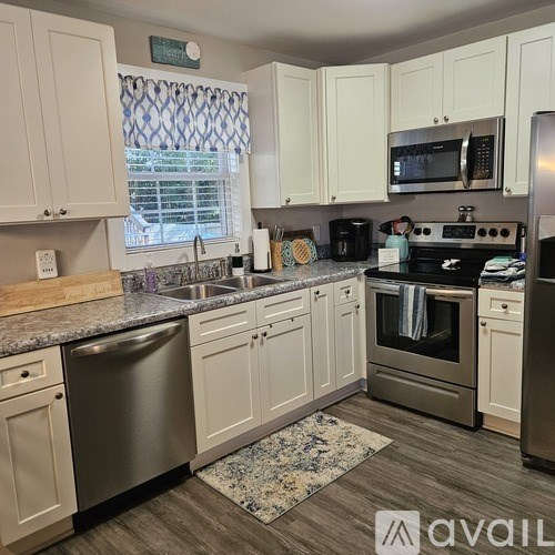 A kitchen with white cabinets and stainless steel appliances.