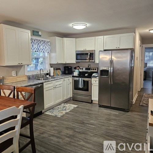 A kitchen with white cabinets and a wooden table.