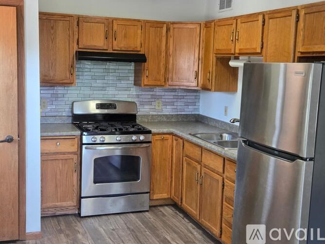 A kitchen with wooden cabinets and stainless steel appliances.
