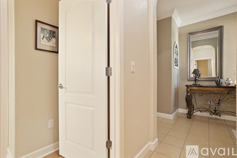 A white door with a mirror and a table with candles on it.