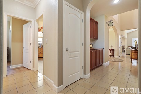A hallway with a white door and a brown cabinet.