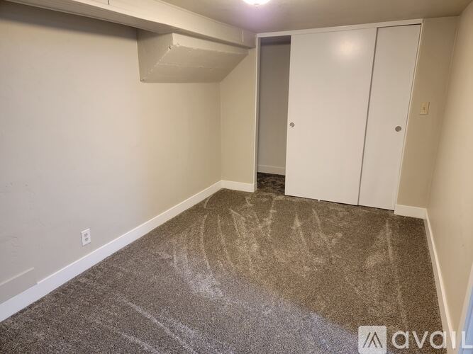 A room with a carpeted floor and two white doors.