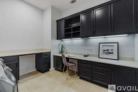 A kitchen with black cabinets and a white countertop.