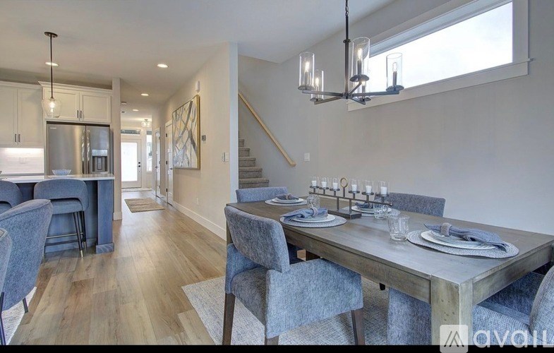A modern dining room with a wooden table and grey chairs.