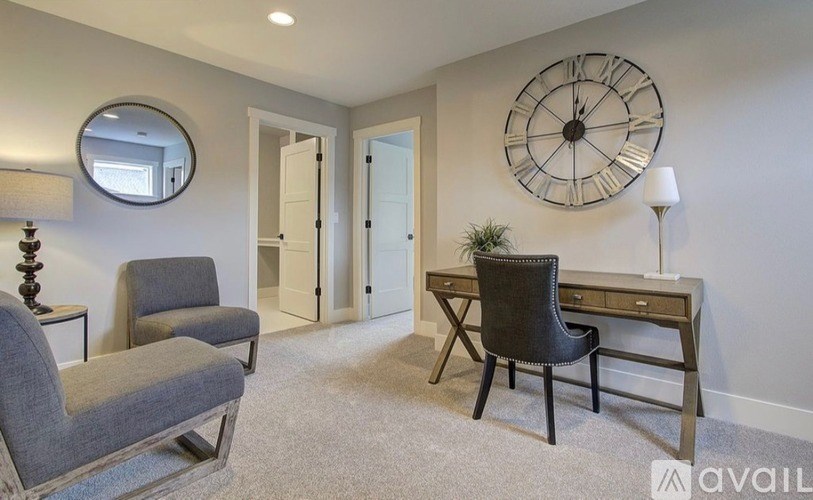A room with a grey carpet and a black chair.