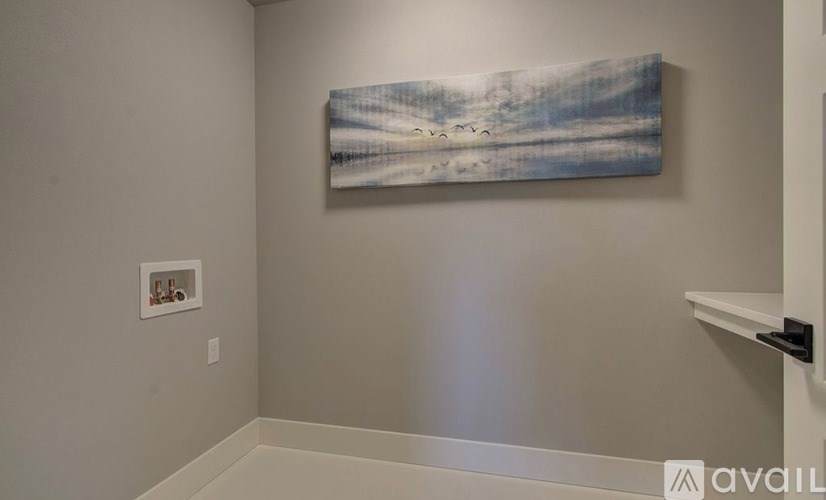 A painting of a beach scene hangs on a wall in a room.