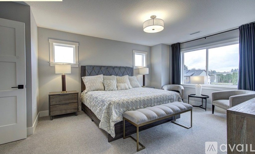 A bedroom with a large bed and a window overlooking a landscape.