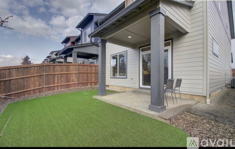A house with a grey siding and a brown fence.