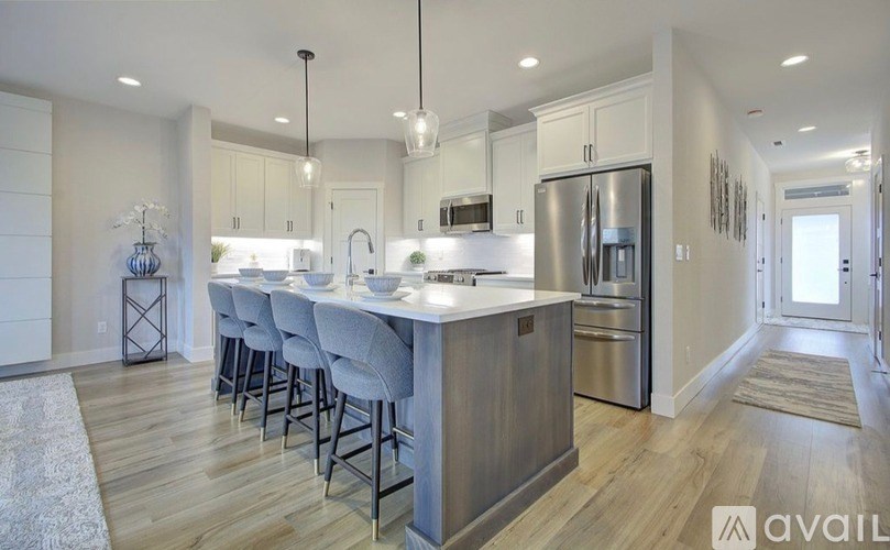 A modern kitchen with a large island and stainless steel appliances.