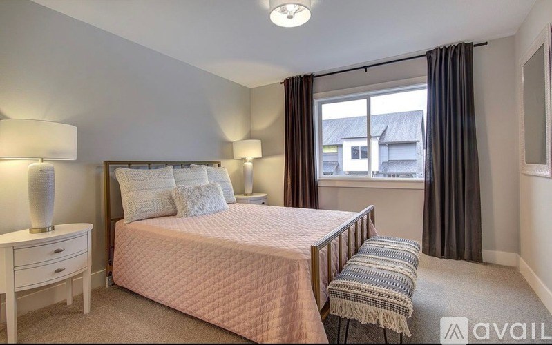 A bedroom with a bed, nightstand, and chair.