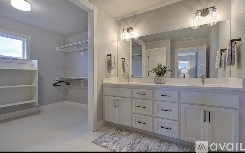 A bathroom with a white vanity and a large mirror.