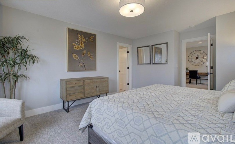 A bedroom with a bed, dresser, and chair.