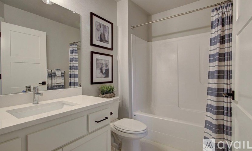 A bathroom with a white toilet, sink, and shower.