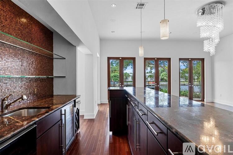 A modern kitchen with dark wood cabinets and a brick backsplash.