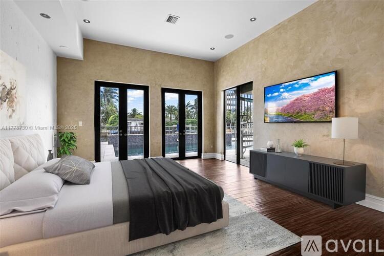 A modern bedroom with a large bed and a flat screen TV mounted on the wall.
