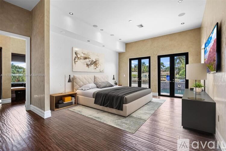 A bedroom with a large bed and a balcony overlooking a green landscape.